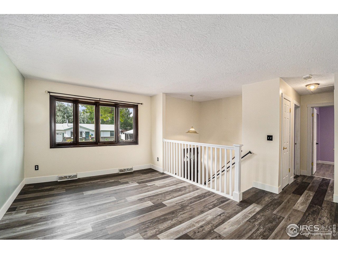 1240 3rd Street Eaton, CO 80615 - Photo 3 of 24 a view of an empty room with wooden floor and a window