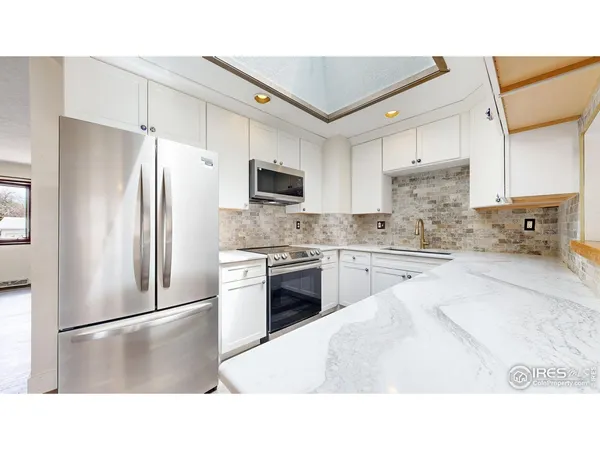 a kitchen with a refrigerator a stove top oven a sink and cabinets
