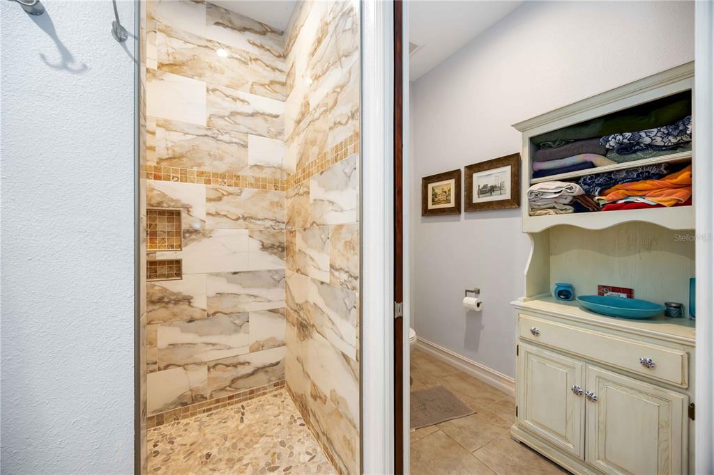 3674 Roslyn Road Venice, FL 34293 - Photo 23 of 72 a hallway with painting on the wall and a potted plant