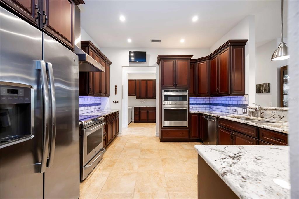 3674 Roslyn Road Venice, FL 34293 - Photo 29 of 72 a kitchen with stainless steel appliances kitchen island granite countertop a stove refrigerator and oven