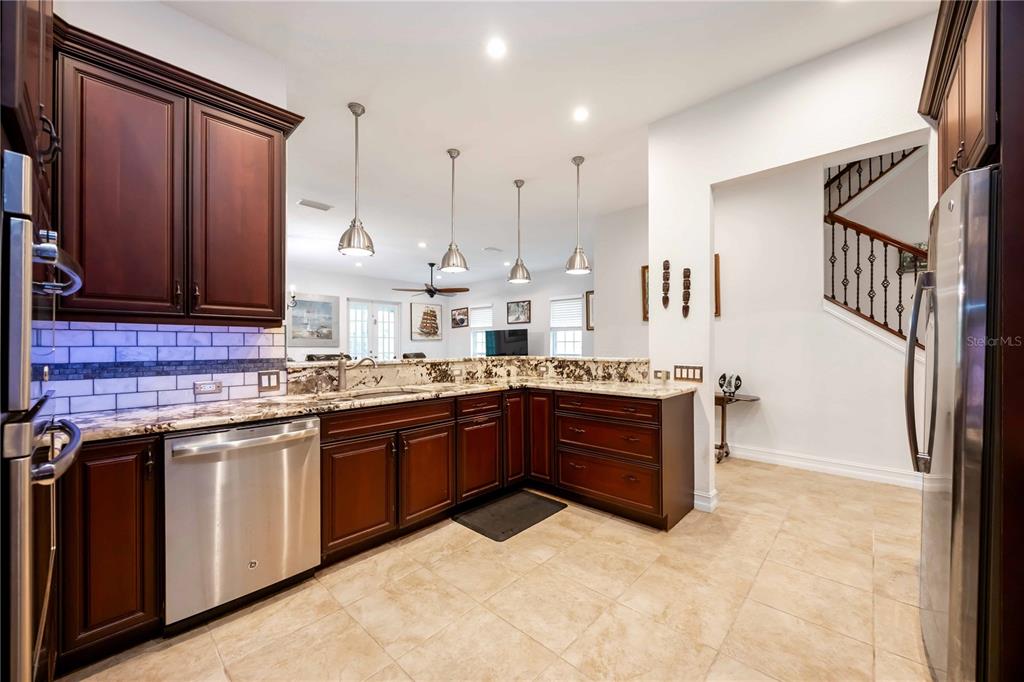 3674 Roslyn Road Venice, FL 34293 - Photo 31 of 72 a large kitchen with stainless steel appliances granite countertop a sink and cabinets