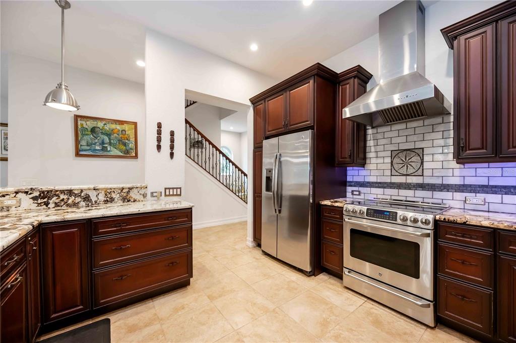 3674 Roslyn Road Venice, FL 34293 - Photo 32 of 72 a kitchen with stainless steel appliances granite countertop a stove and a refrigerator
