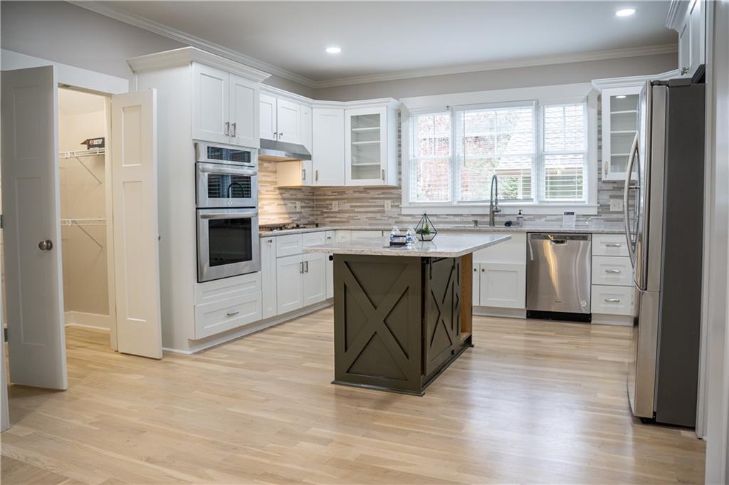 151 Cherokee Point Drive Canton, GA 30114 - Photo 89 of 163 a kitchen with stainless steel appliances granite countertop a stove a sink dishwasher a refrigerator and white cabinets with wooden floor