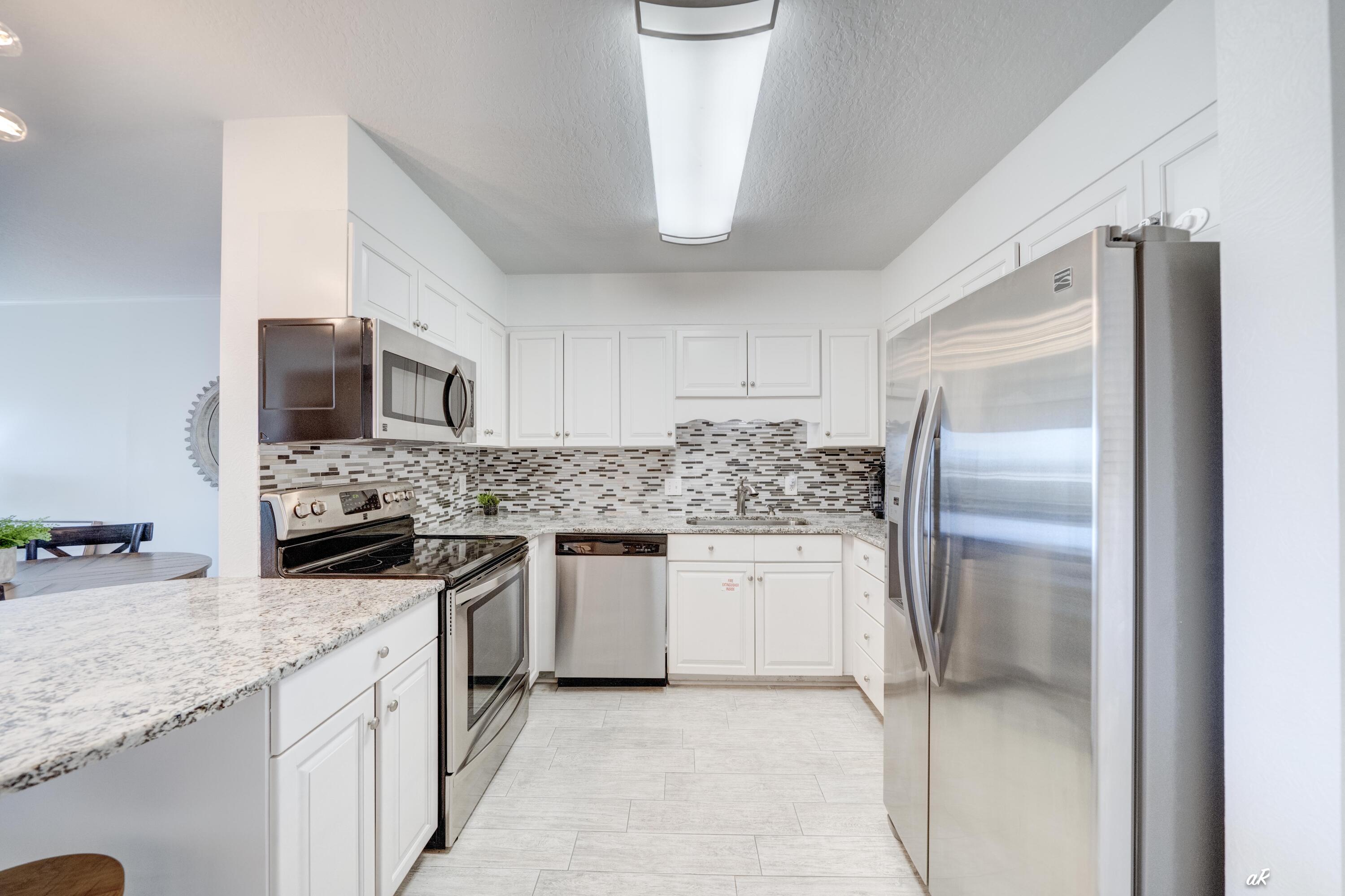 30 Moreno Point Road, Unit 404A Destin, FL 32541 - Photo 4 of 52 a kitchen with a sink stove and refrigerator