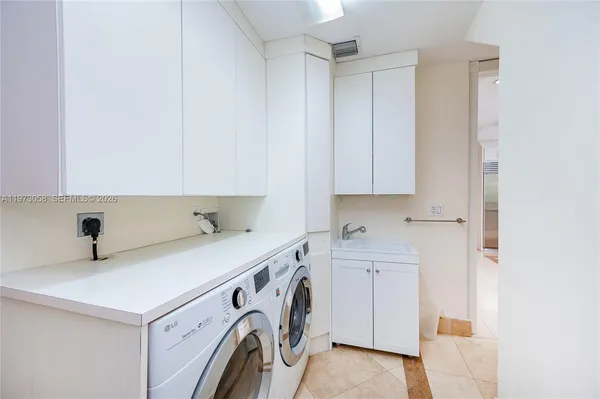a view of an empty room with cabinet and mirrors