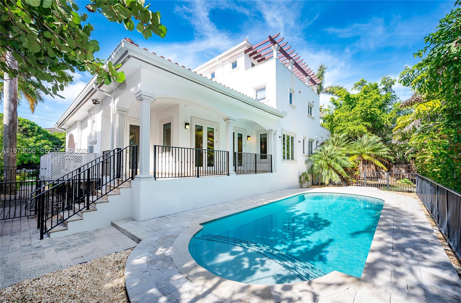 541 South Mashta Drive Key Biscayne, FL 33149 - Photo 25 of 28 a view of a white house with a small yard plants and large tree