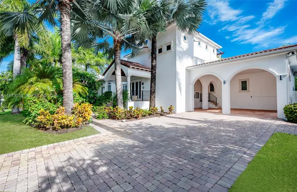 a view of a white house with a yard and potted plants