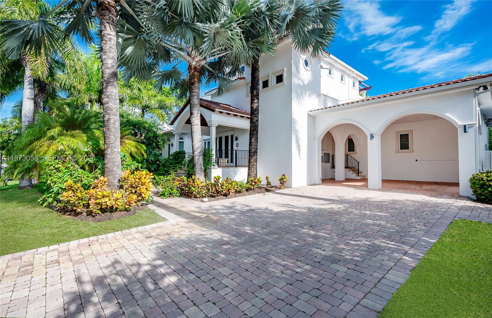 541 South Mashta Drive Key Biscayne, FL 33149 - Photo 4 of 28 a view of a white house with a yard and potted plants