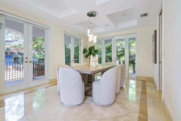 a dining room with furniture and a floor to ceiling window