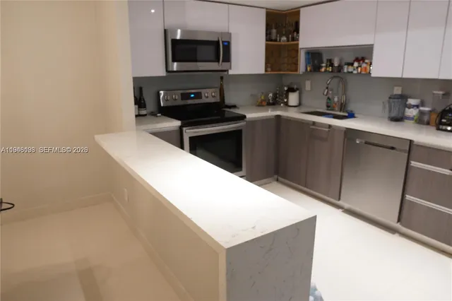 a kitchen with a sink a microwave and cabinets