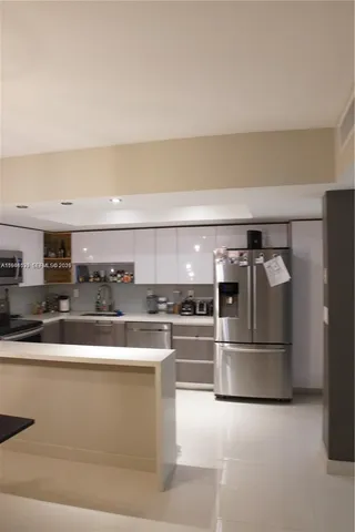 a kitchen with stainless steel appliances granite countertop a refrigerator and a stove