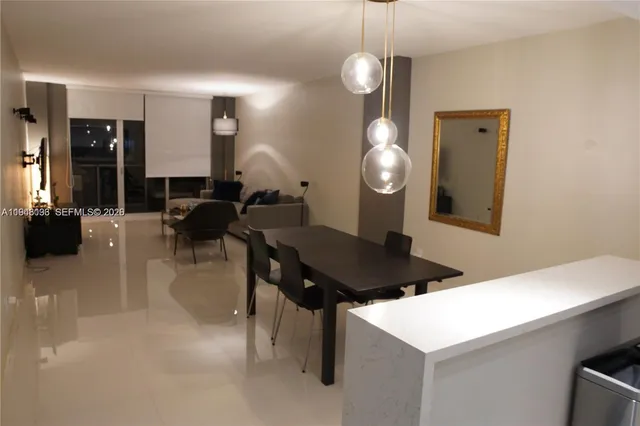 a living room with table chairs and a chandelier