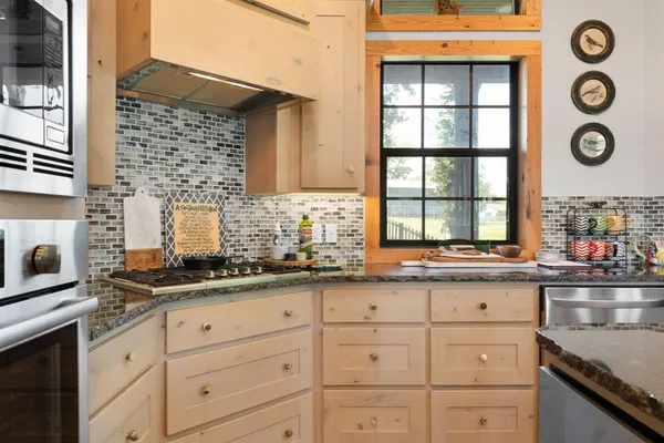 a kitchen with granite countertop white cabinets and window