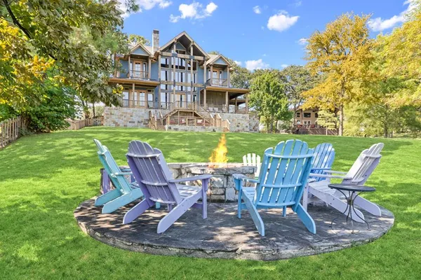 a view of a lake with a table and chairs next to a yard