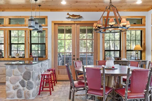 a dining room with furniture a chandelier and wooden floor