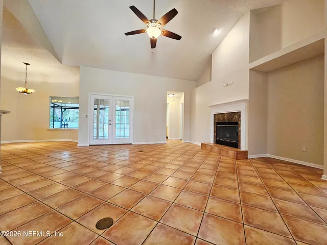 a view of an empty room with window and fireplace