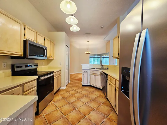 a kitchen with stainless steel appliances a refrigerator sink and microwave