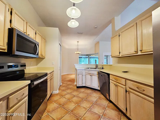 a kitchen with stainless steel appliances granite countertop a stove top oven a sink dishwasher and a microwave oven on the blue kitchen countertops