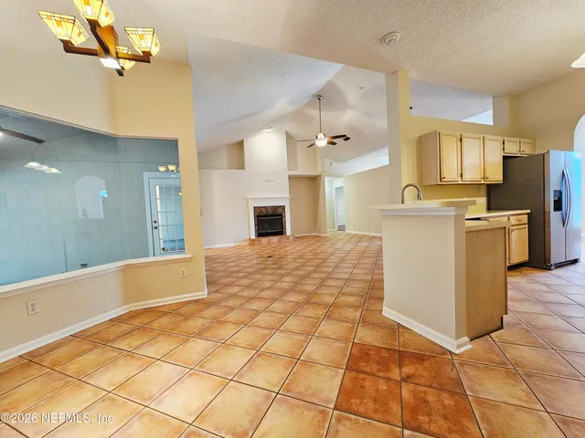 a large kitchen with stainless steel appliances kitchen island granite countertop a refrigerator and a stove top oven