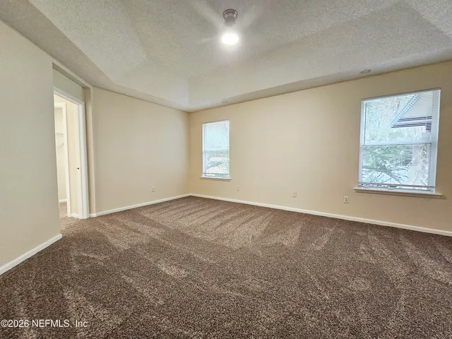 an empty room with windows and closet