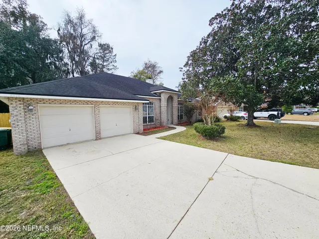 a view of a white house with a large tree