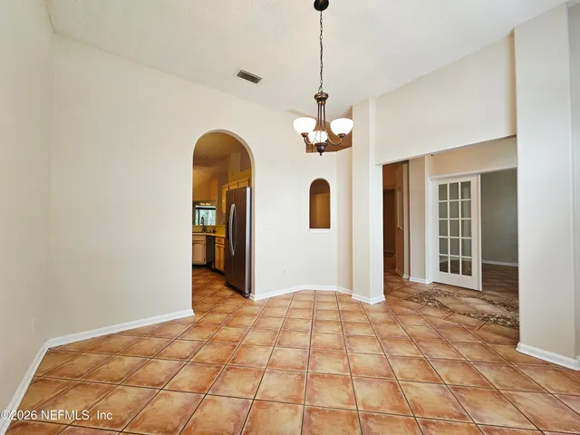 a view of a hallway with a chandelier and entryway
