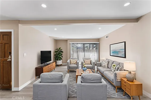 a living room with furniture a flat screen tv and a window