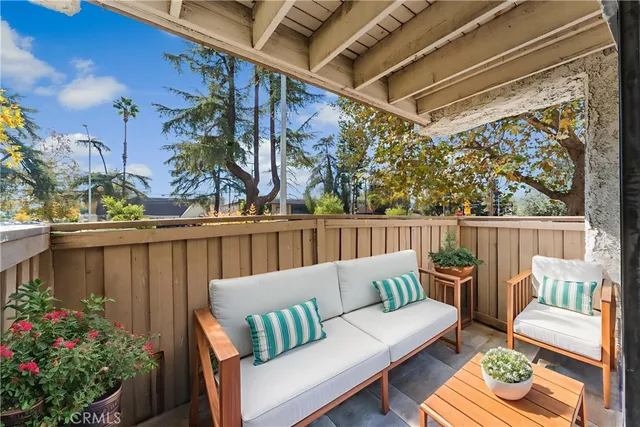 a balcony with wooden floor and outdoor seating