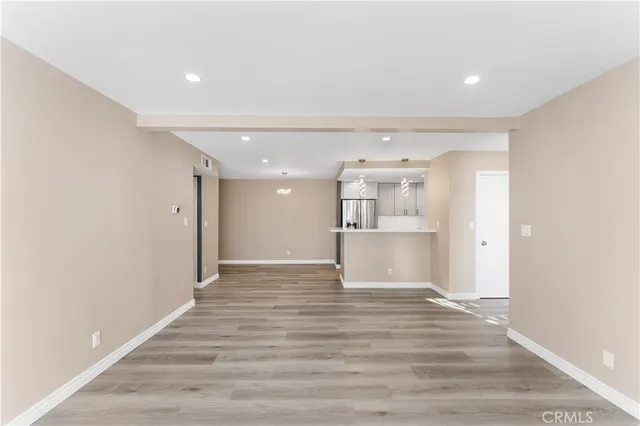 a view of empty room with wooden floor