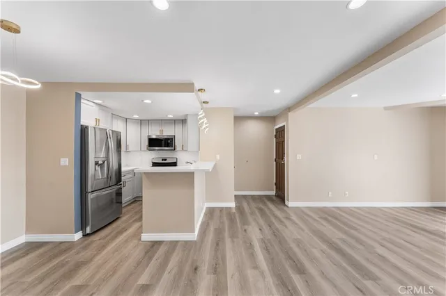 a view of kitchen view wooden floor and stainless steel appliances