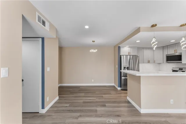 a view of kitchen with stainless steel appliances cabinets and wooden floor