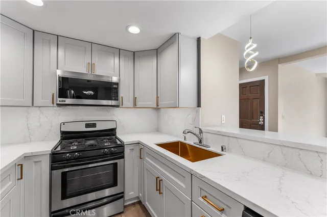 a kitchen with cabinets stainless steel appliances and a sink