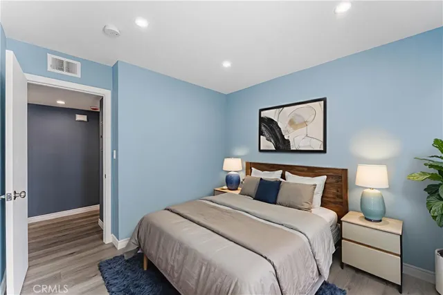 a bedroom with a bed and a painting on the wall