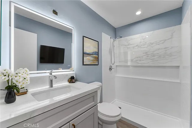 a bathroom with a double vanity sink toilet and mirror