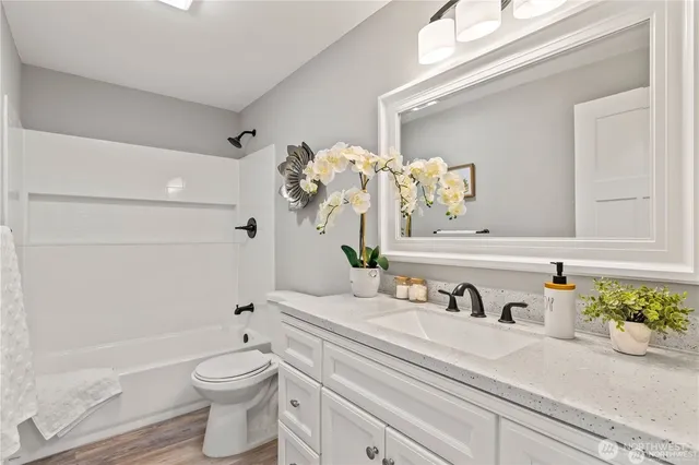 a bathroom with a sink a toilet and a mirror