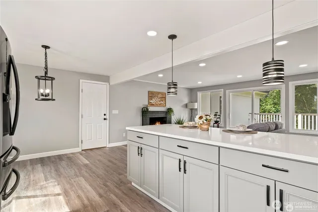 a kitchen with kitchen island white cabinets and wooden floor