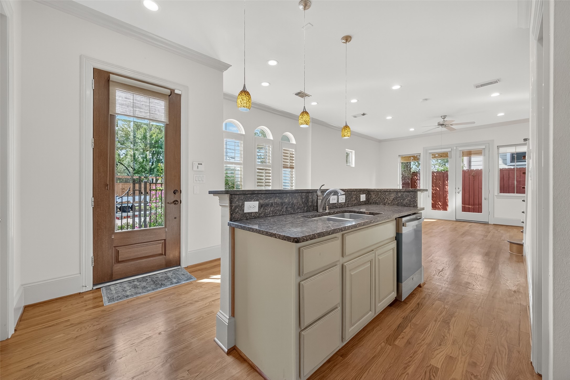 931 West 23rd Street, Unit K Houston, TX 77008 - Photo 11 of 40 Kitchen features island with breakfast bar, crown molding, 3 pendant lights, recessed lights, under cabinet lights and reverse osmosis water filtration system.