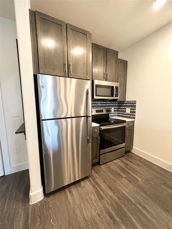 6080 Water Street, Unit 2460 Plano, TX 75024 - Photo 3 of 9 a kitchen with wooden floors and stainless steel appliances