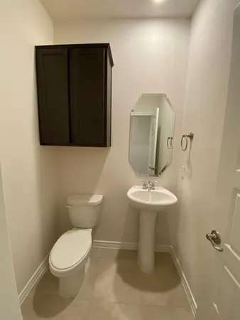 a bathroom with a toilet a sink and mirror