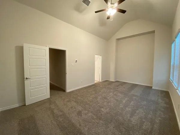 an empty room with closet and a ceiling fan