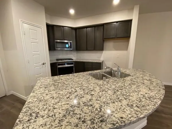 a kitchen with a sink and a stove top oven