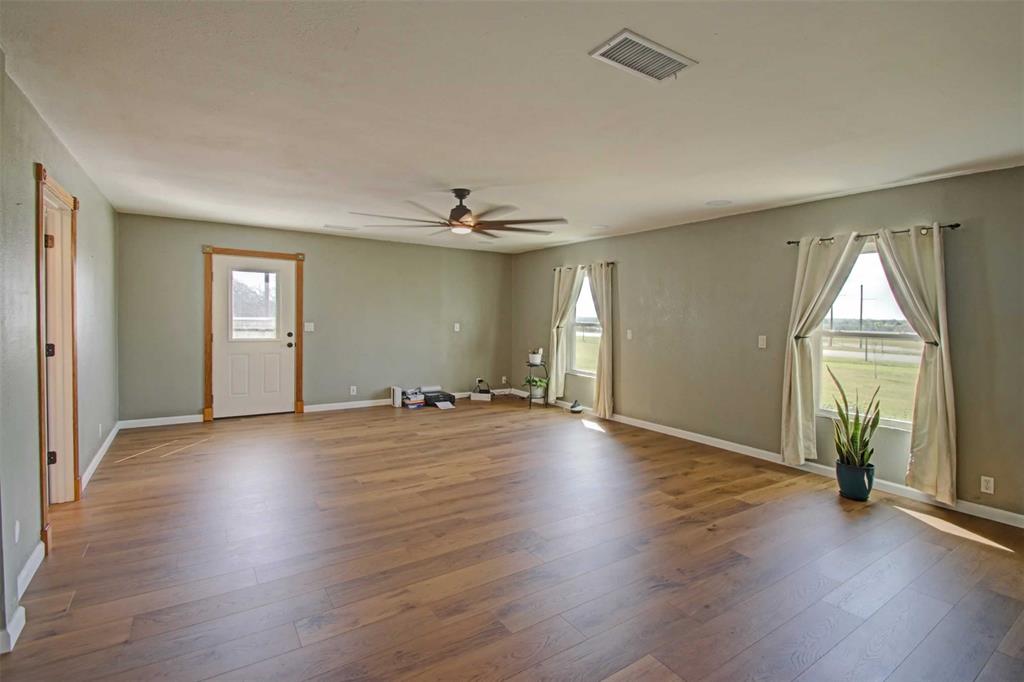 3559 Springfield Road Springtown, TX 76082 - Photo 3 of 36 an empty room with wooden floor and windows