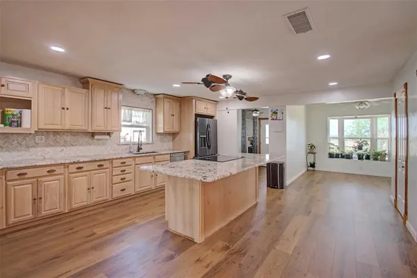 a kitchen with stainless steel appliances granite countertop a stove and a wooden floors