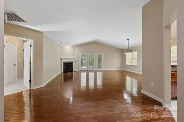 a view of empty room with wooden floor and fireplace