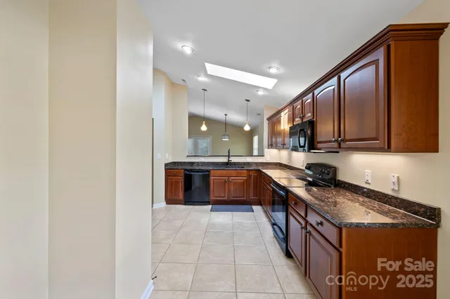 a large kitchen with stainless steel appliances granite countertop a large counter top and a stove