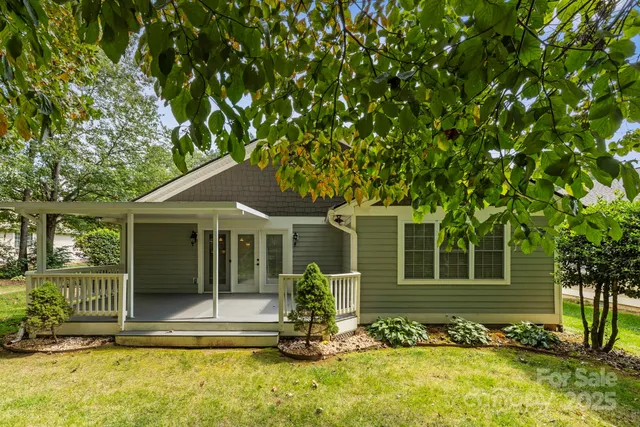a front view of a house with a tree in it