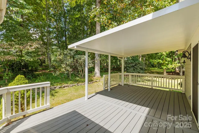 a balcony with wooden floor and yard in the back