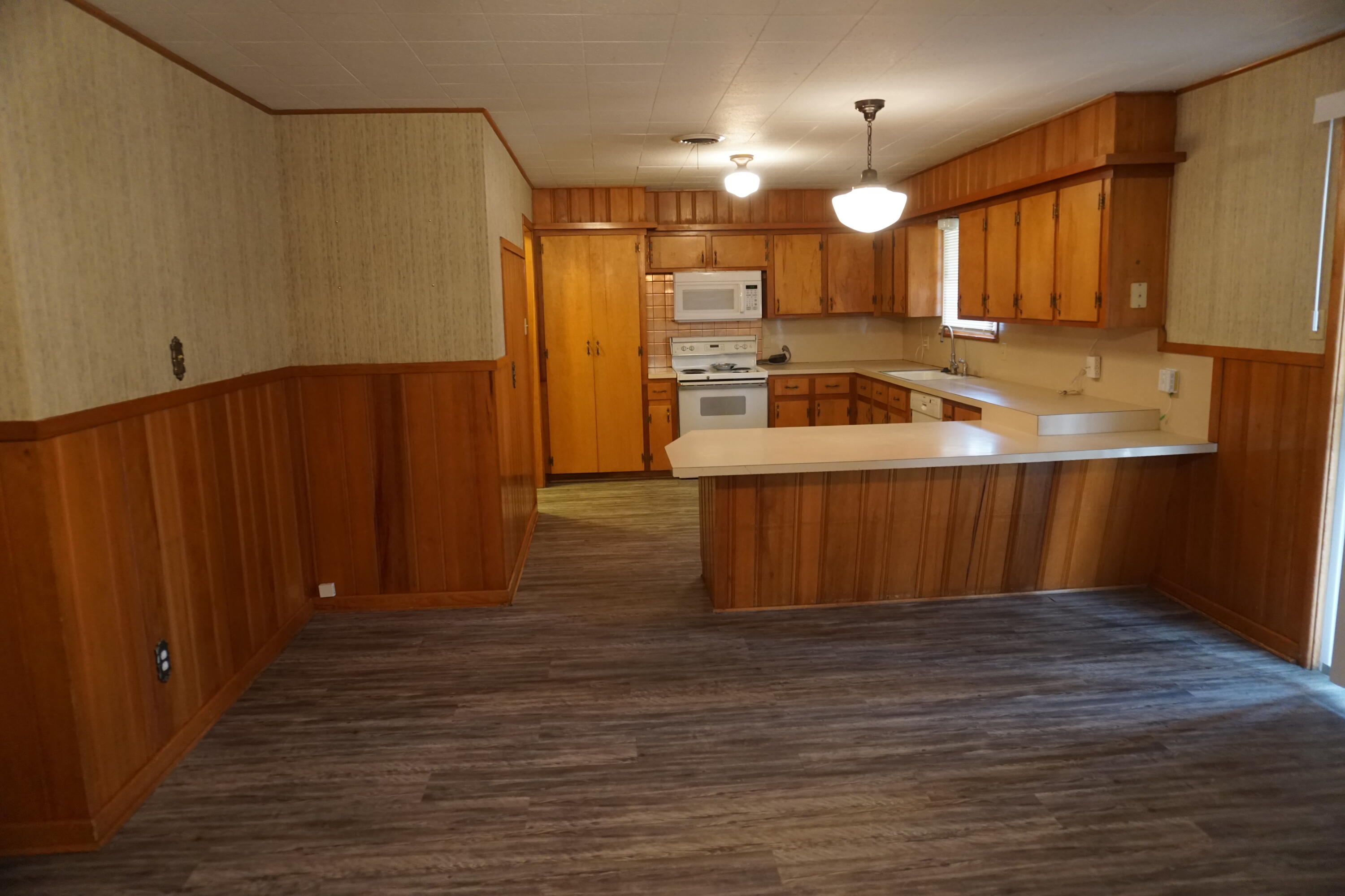 5414 7th Street Lubbock, TX 79416 - Photo 3 of 11 a kitchen with wooden cabinets and refrigerator