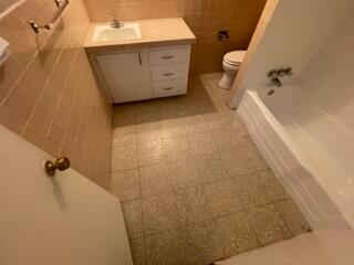 5414 7th Street Lubbock, TX 79416 - Photo 5 of 11 a bathroom with a granite countertop sink a toilet and shower