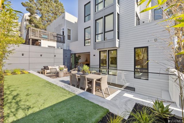 a kitchen with stainless steel appliances granite countertop a stove top oven a sink a dining table and chairs with wooden floor